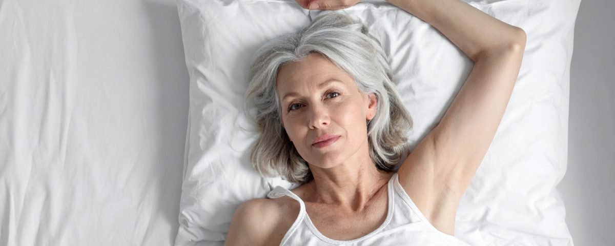Woman laying down so she can perform a breast self exam